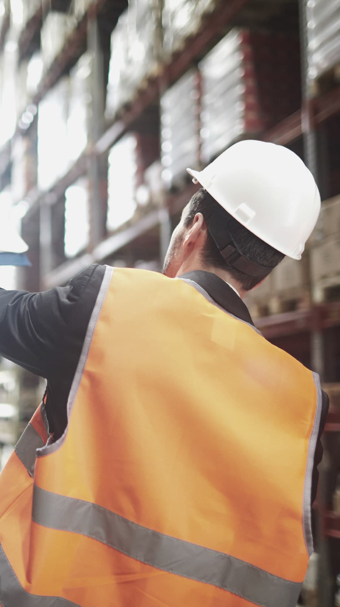 A worker in a hard hat and high-visibility vest on a job site